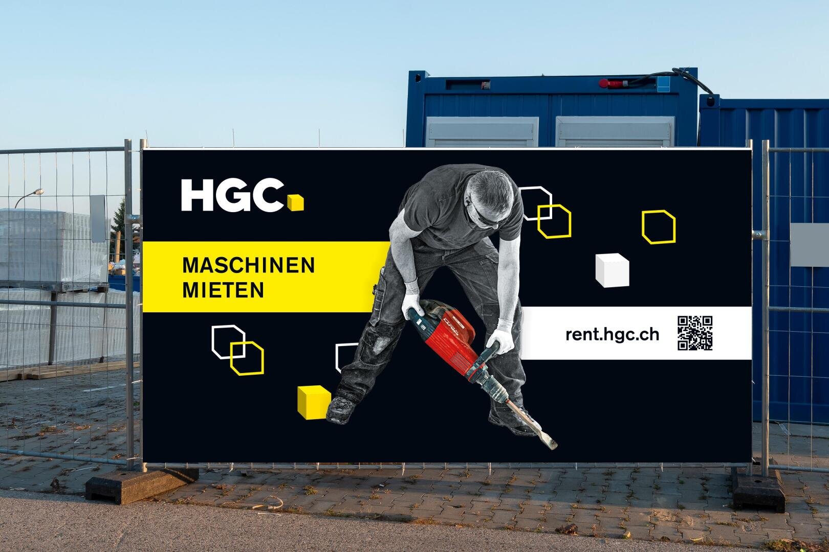 Ein Baustellenbanner, das einen Mann mit einem Elektrowerkzeug zeigt, mit dem Text HGC. MASCHINEN MIETEN und rent.hgc.ch auf schwarzem Hintergrund mit gelben und weissen geometrischen Formen.