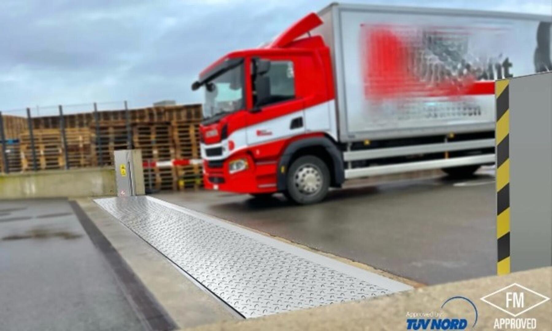 Ein rot-weißer Lieferwagen parkt in der Nähe einer Metallwaage in einer Logistikanlage. Im Hintergrund sind gestapelte Paletten zu sehen und Sicherheitsmarkierungen an den umliegenden Gebäuden.