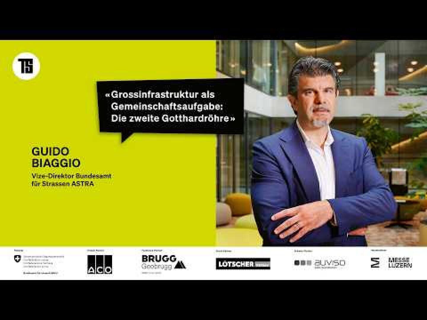 Ein Mann in einem marineblauen Anzug steht in einem modernen Büro. Der Text lautet: Guido Biaggio, Vize-Direktor Bundesamt für Strassen ASTRA und in einem gelben Kasten steht: Grossinfrastruktur als Gemeinschaftsaufgabe: Die zweite Gotthardröhre.