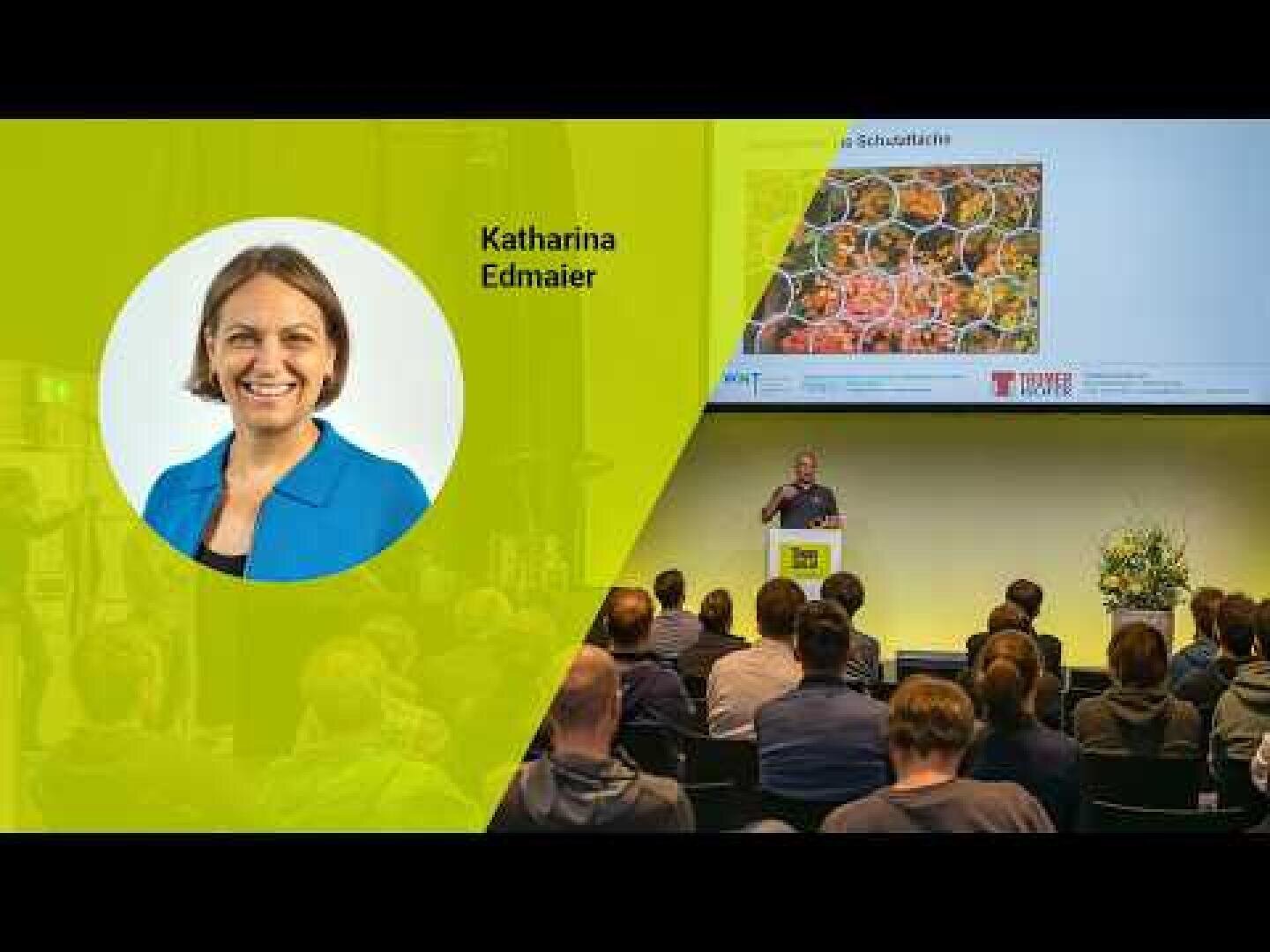 Vor einem Publikum findet gerade eine Präsentation statt. Auf dem Bildschirm ist ein Dia zu sehen, das bunte Lebensmittel und den Namen Katharina Edmaier zeigt, daneben das Porträt einer lächelnden Frau in einer blauen Jacke.