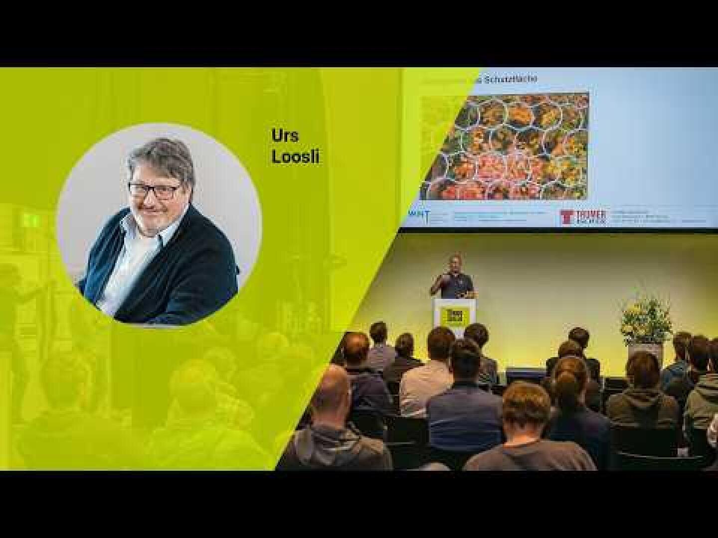 Auf der linken Seite ist ein Mann namens Urs Loosli abgebildet, während er auf der rechten Seite vor einem Publikum in einem Konferenzraum einen Vortrag mit einer Folie hält, die Bienenwaben zeigt.